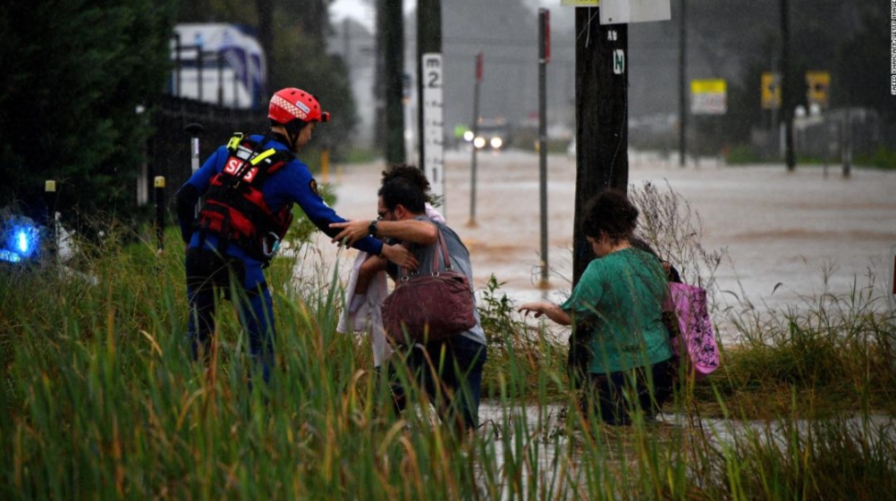 一名救援人员帮助居民穿越悉尼西部的一条被水淹没的街道。.jpg
